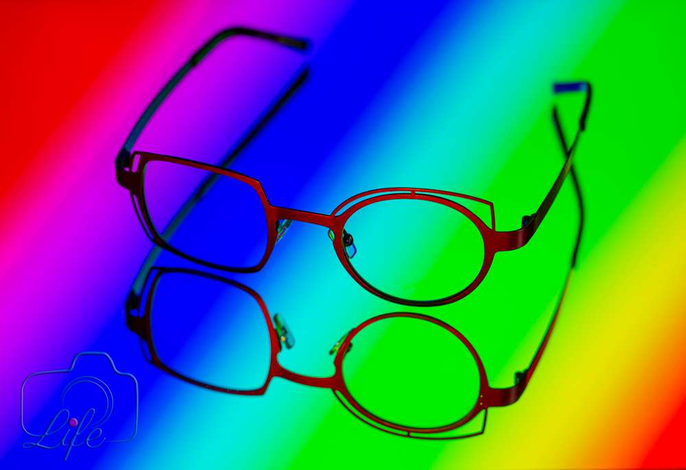 Werbe-Foto: Brille auf im Spiegel gespiegelten Regenbogenfarben